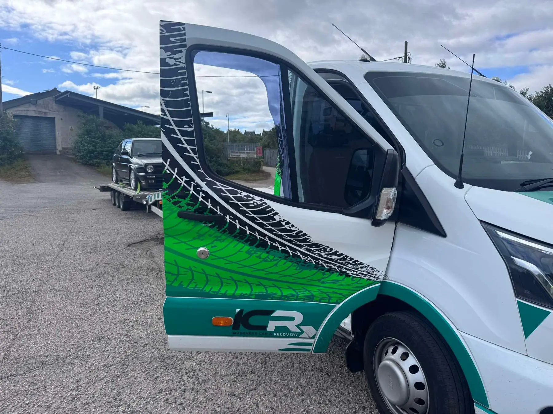 White car secured for roadside transport beside the ICR cab