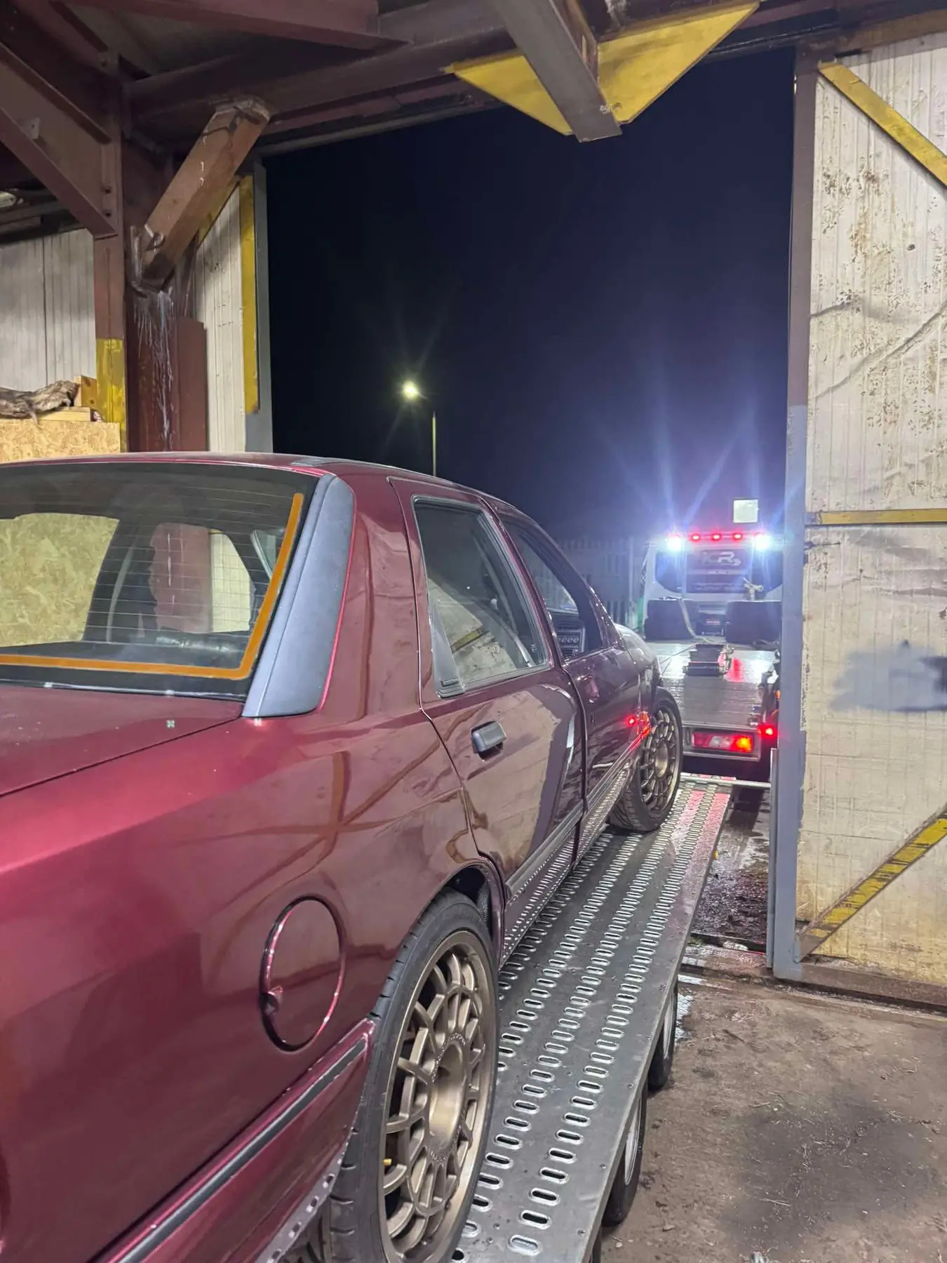 Classic car being collected from a workshop by ICR at night